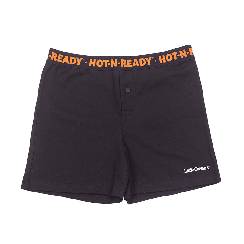 Front view of black boxers with orange repeating Hot-N-Ready® logo on waitband and white Little Caesars® logo on lower left leg.